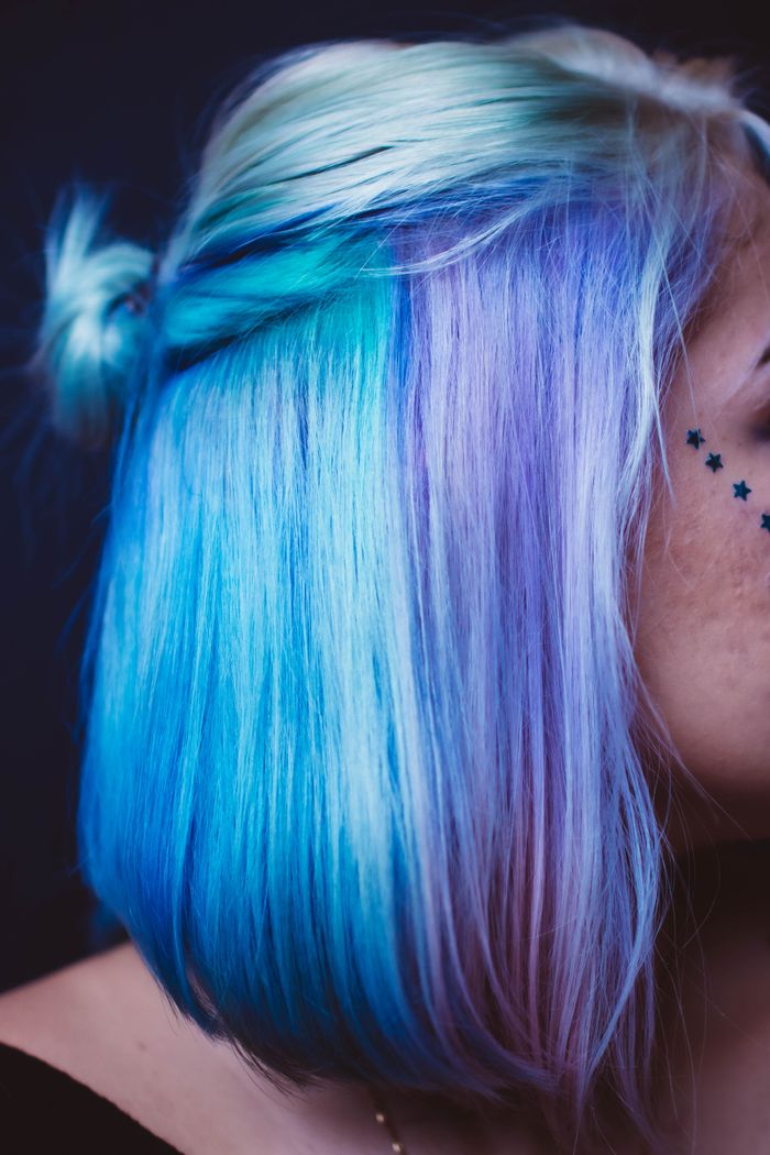 Portrait showcasing colorful hair and star tattoo, emphasizing rebellious unique style.
